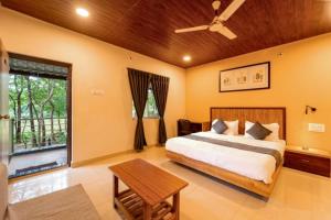 a bedroom with a bed and a large window at Rain Forest Jungle Stay in Kurandi +13 photos