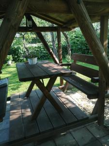 a wooden picnic table and a bench on a patio at Köleri B&B in Suure-Jaani