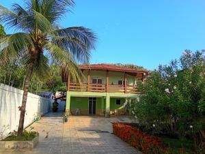 a house with a palm tree in front of it at Araçagy Casa Mar in São José de Ribamar