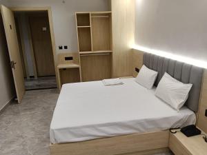 a bedroom with a large bed with white sheets at Hotel Radian INN in Gorakhpur