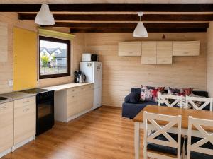 a kitchen and living room with a couch and a table at DOMKI NA FALI by Baltic Club in Sarbinowo