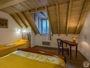 a bedroom with two beds and a table and a desk at Le castillon in Marignac