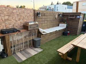 a patio with a bench and a table and a brick wall at Les Chambres de Paulette - LOGEMENTS A THEMES - CHAMBRE JACK SPARROW - CHAMBRE KOH LANTA - CHAMBRE HARRY POTTER - CHAMBRE ZEN in Sainte-Marie-la-Mer