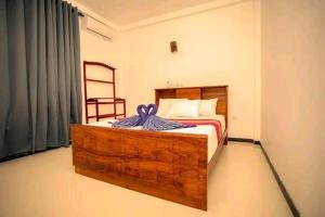 a bedroom with a bed with a wooden bed frame at Villa Akeinya in Matara