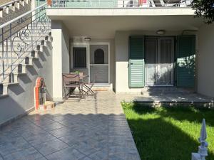 a porch of a house with green doors and chairs at Jim's House in Káspakas