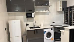 a kitchen with a sink and a washing machine at Parkside City Apts in Accra