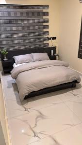 a bedroom with a large bed with a black headboard at Parkside City Apts in Accra