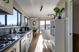 a kitchen with white cabinets and a sink and a tub at Six-Ten Shores in Dolphin Sands