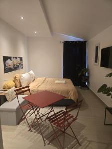 a bedroom with a bed and a table and chairs at L'instant cosy climatisé 2 in Sisteron