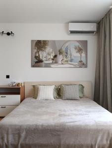 a bedroom with a bed and a picture on the wall at Sea Breeze Studio at Fort Noks Resort in Sunny Beach