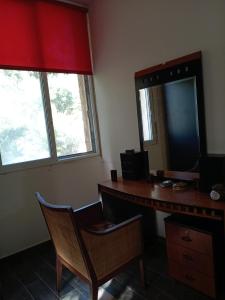 an office with a desk with a mirror and a chair at Khalle lodge in Dayr al Qamar
