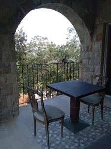 a table and two chairs sitting next to a balcony at Khalle lodge in Dayr al Qamar
