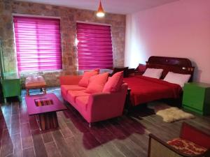 a bedroom with a red bed and a couch at Khalle lodge in Dayr al Qamar +36 photos