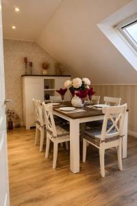 a dining room with a white table and chairs at Ferienwohnung Am Wäldchen in Vöhl
