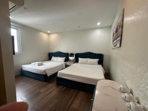 a small room with two beds and a table at Hanoi Better Hotel & spa in Hanoi