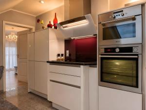 a kitchen with white cabinets and an oven at Ferienwohnung Am Wäldchen in Vöhl +15 photos