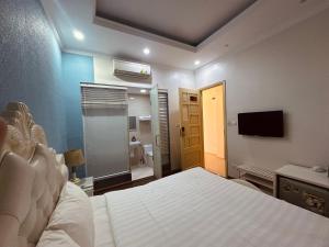 a bedroom with a bed and a television and a bathroom at Hanoi Better Hotel & spa in Hanoi