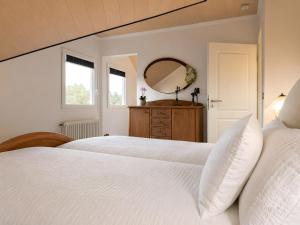 a bedroom with two white beds and a mirror at Ferienwohnung Am Wäldchen in Vöhl