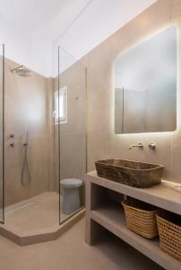 a bathroom with a sink and a toilet and a mirror at Aurum Suites Sifnos in Kamares +14 photos