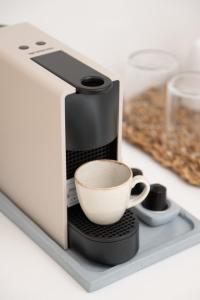 a coffee maker with a cup on a counter at Aurum Suites Sifnos in Kamares