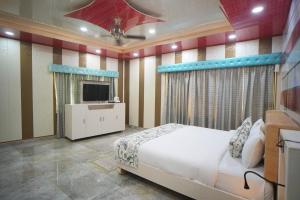 a bedroom with a bed and a tv in it at MSG Hotels And Resort in Sirsa