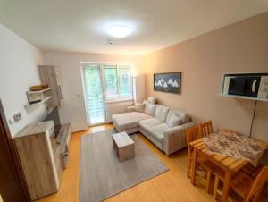 a living room with a couch and a table at Apartments Tatra Olla - Tatranská Lomnica in Tatranská Lomnica