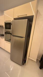 a refrigerator in a kitchen with a microwave at إقامة الرمال الذهبية in Les Hamiane +6 photos