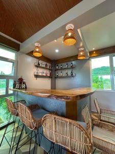 a bar with chairs and a counter in a room at Green Field Resort Hotel in Anda