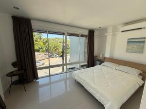 a bedroom with a bed and a large window at The CHU cafe / guesthouse in Nai Harn Beach +54 photos