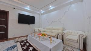 a living room with a couch and a table at ESAL House in Karakol +26 photos