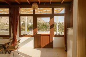 a dining room with a door and a table and chairs at Birds Villa Apartments with Heated Pool - Including Car and Breakfast in Perissa