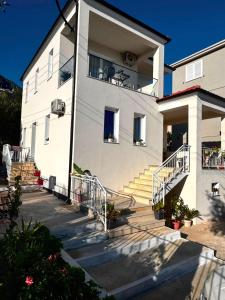 a white house with stairs in front of it at Villa Thalassa Lal'Andrea in Dhërmi