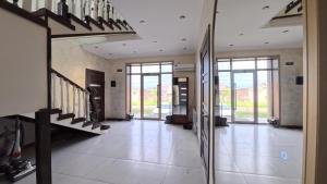 a hallway of a house with stairs and glass doors at ESAL House in Karakol