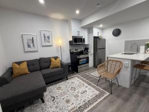 a living room with a couch and a kitchen at Modern Rangeview Stay Near YMCA & Cineplex Cinema in Calgary
