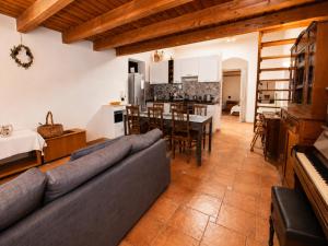 a large living room with a couch and a kitchen at Casa del Carrubo con Piscina, relax in campagna vicino al mare in Santa Croce Camerina