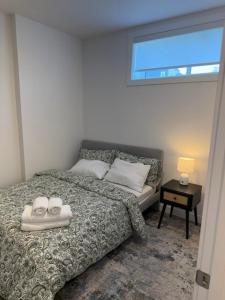 a bedroom with a bed with two shoes on it at Modern Rangeview Stay Near YMCA & Cineplex Cinema in Calgary