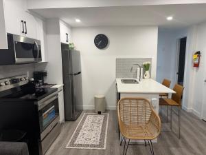 a kitchen with a sink and a table with a counter at Modern Rangeview Stay Near YMCA & Cineplex Cinema in Calgary +13 photos