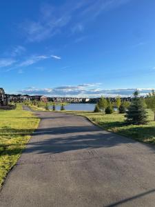 an empty road with a view of a lake at Modern Rangeview Stay Near YMCA & Cineplex Cinema in Calgary