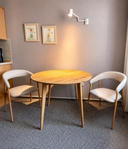 a table and two chairs and a table and a lamp at Heideapartments Hillmer in Bispingen +26 photos