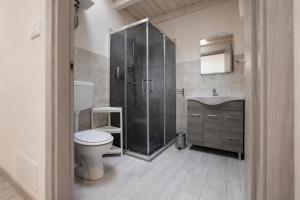 a bathroom with a shower and a toilet and a sink at Casa del Carrubo con Piscina, relax in campagna vicino al mare in Santa Croce Camerina +20 photos