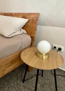 a table with a lamp on it next to a bed at Heideapartments Hillmer in Bispingen