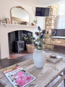 a living room with a vase with flowers on a table at Castle Cottage Winchcombe in Winchcombe