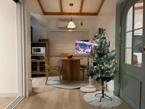 a living room with a christmas tree and a kitchen at 스테이 모슬 in Daejeong