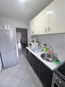 a kitchen with a sink and a white refrigerator at Sweet Home in Tuzla