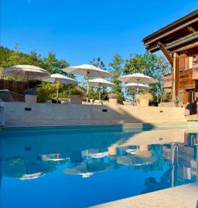 a swimming pool with umbrellas in a resort at Hôtel et Spa Le Vermont in Le Grand-Bornand