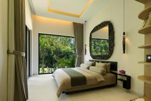a bedroom with a bed and a large window at Mandalore Villas Ubud - Adults Only in Ubud