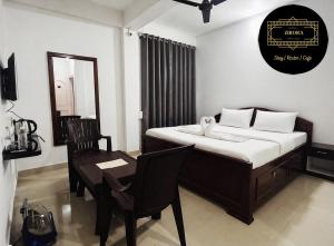 a bedroom with a bed and a chair and a desk at Hotel Zirora in Ziro
