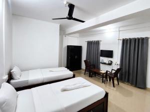 a hotel room with two beds and a table and chairs at Hotel Zirora in Ziro +5 photos