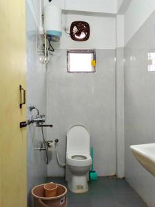 a small bathroom with a toilet and a sink at Hotel Zirora in Ziro