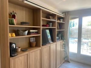a large wooden entertainment center with a tv in it at Les OLIVETTES CLIMATISÉES d'UZES à Garrigues Sainte Eulalie in Garrigues-et-Sainte-Eulalie